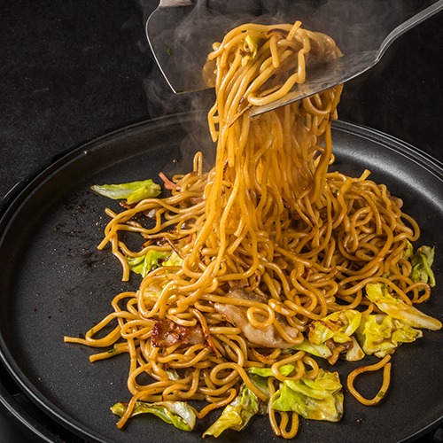 Black pan with lomein noodles cooking